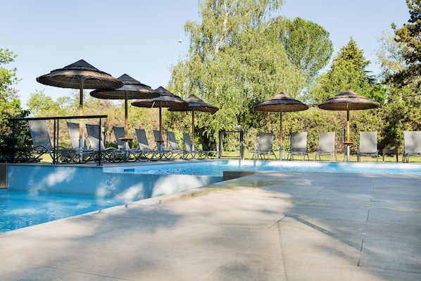 Seasonal outdoor pool, open 9:00 AM to 10:00 PM, pool umbrellas