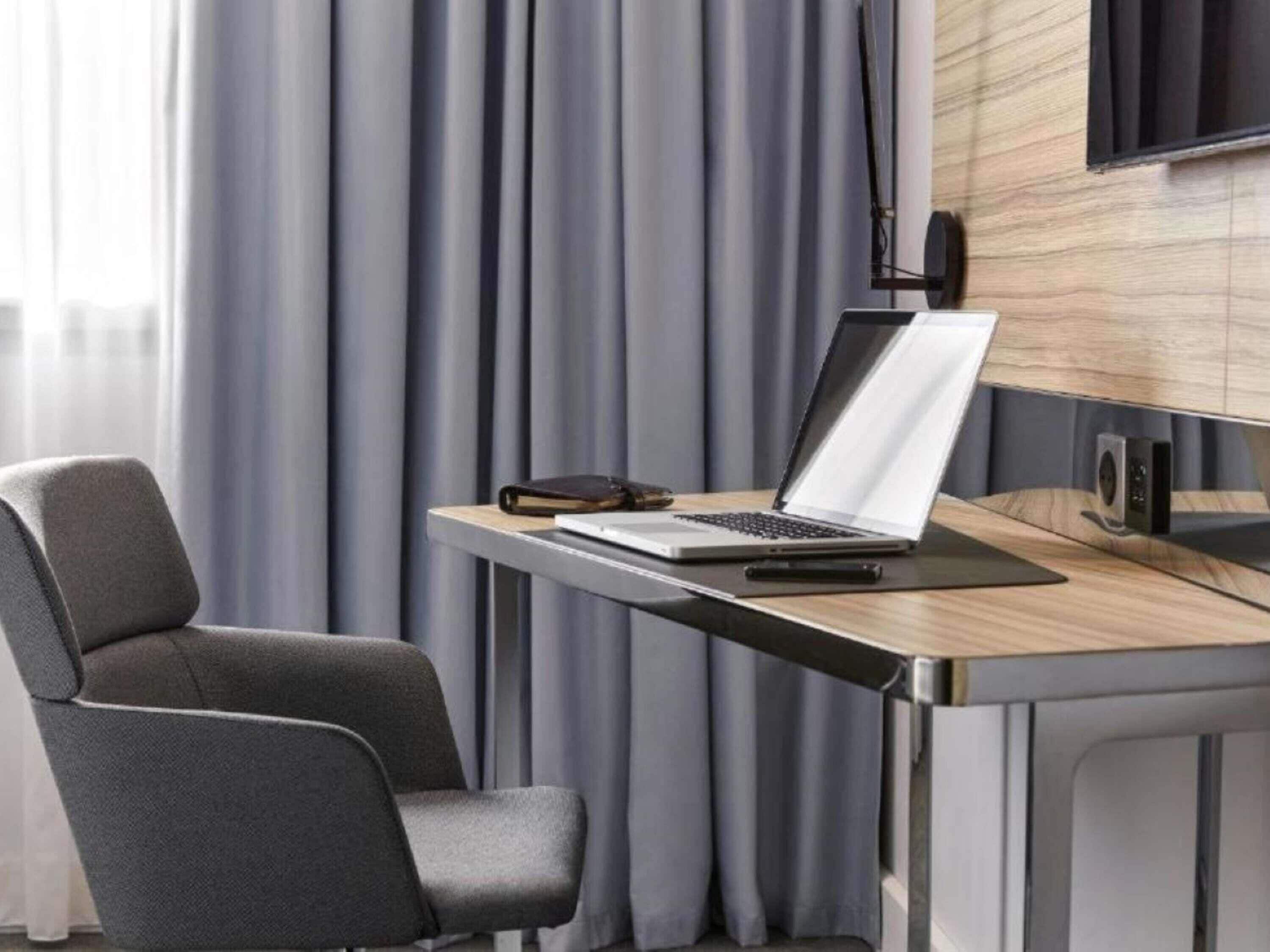 Une chambre moderne équipée d’un bureau, d’une chaise, d’un ordinateur portable et d’un haut-parleur.