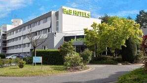 A B&B hotel with a modern design, a parking lot, and well-maintained landscaping.