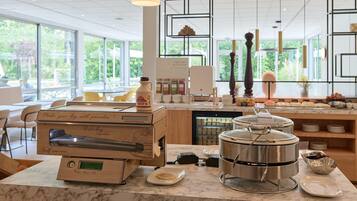A self-service breakfast station with a coffee machine, a yogurt dispenser, and a large pot on the counter.