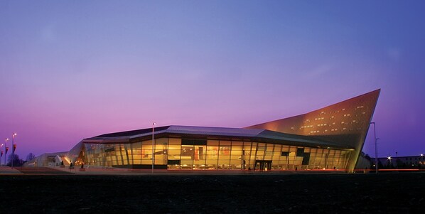 A modern building with a unique angular design, large glass windows, and a sloped roof. - Comfort Inn Ottawa East (Ottawa)