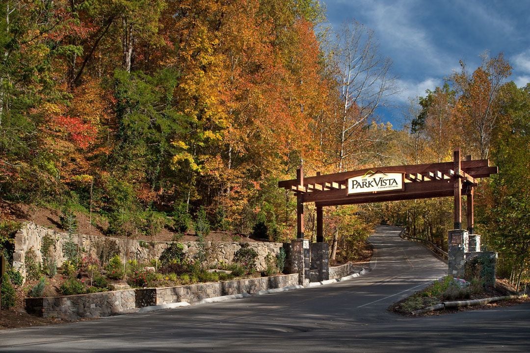 A park entrance with a wooden archway labeled "Park Vista" and a stone wall on the left.