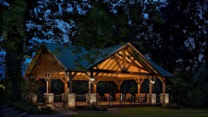 A covered pavilion with stone pillars, a metal roof, and outdoor seating. - The Park Vista - a DoubleTree by Hilton Hotel - Gatlinburg (Gatlinburg)