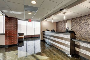 Zona de recepción con mostrador, banco y pared con diseño.