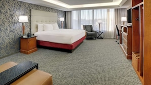 A hotel room with a large bed, a desk, a chair, and a TV. - Drury Inn & Suites Springfield IL (Springfield)