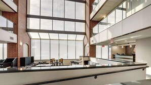 A spacious lobby with high ceilings, large windows, and a central seating area. - Drury Inn & Suites Springfield IL (Springfield)