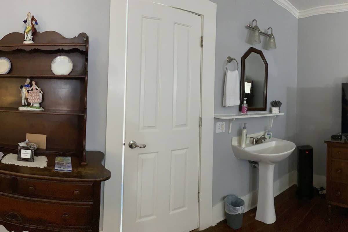 Une chambre à coucher comprenant un lit, une commode, une coiffeuse et un téléviseur.