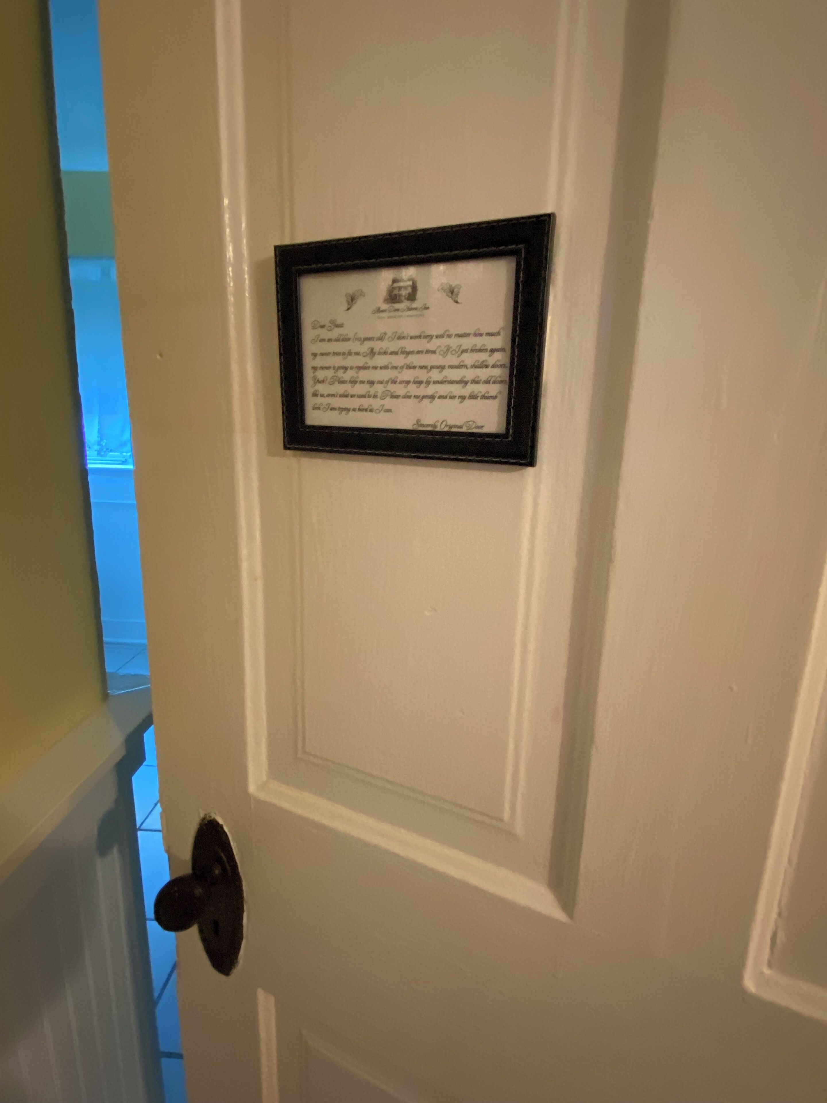 A white door with a framed quote.