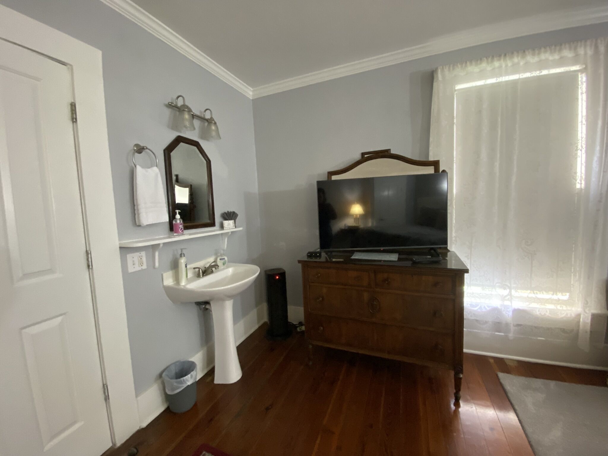 Un baño con lavabo, espejo y tocador.