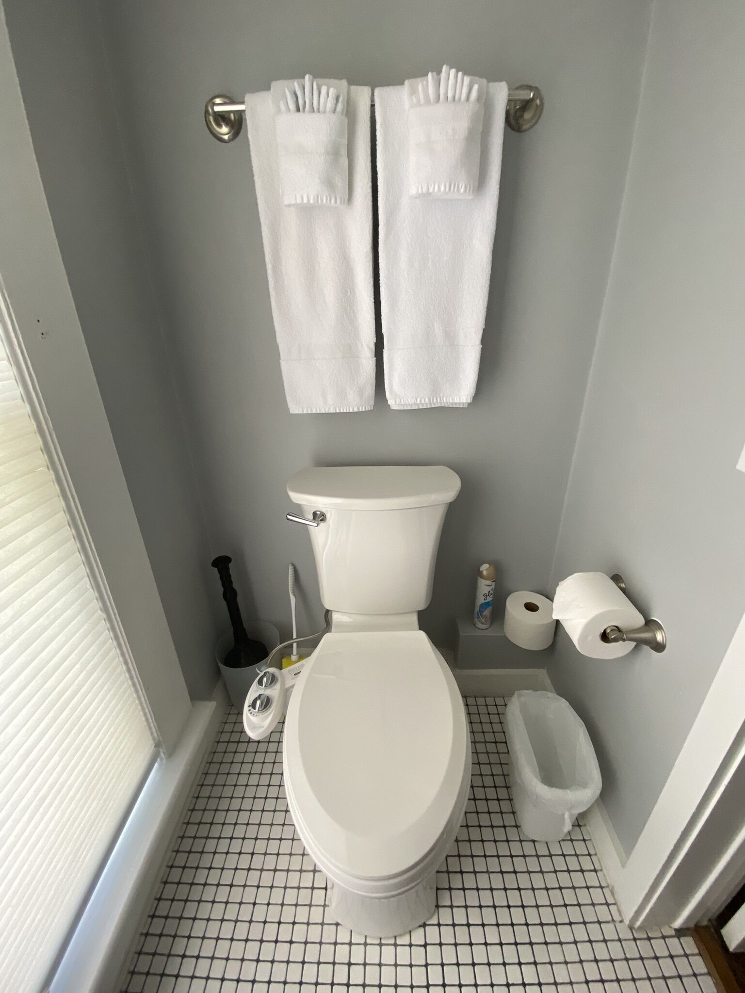 A bathroom with a toilet, bidet, and two towels hanging on a towel bar.