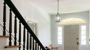 A staircase with wooden balusters leading to a landing with a bench and a door. - Meadows Inn Bed & Breakfast (New Bern)