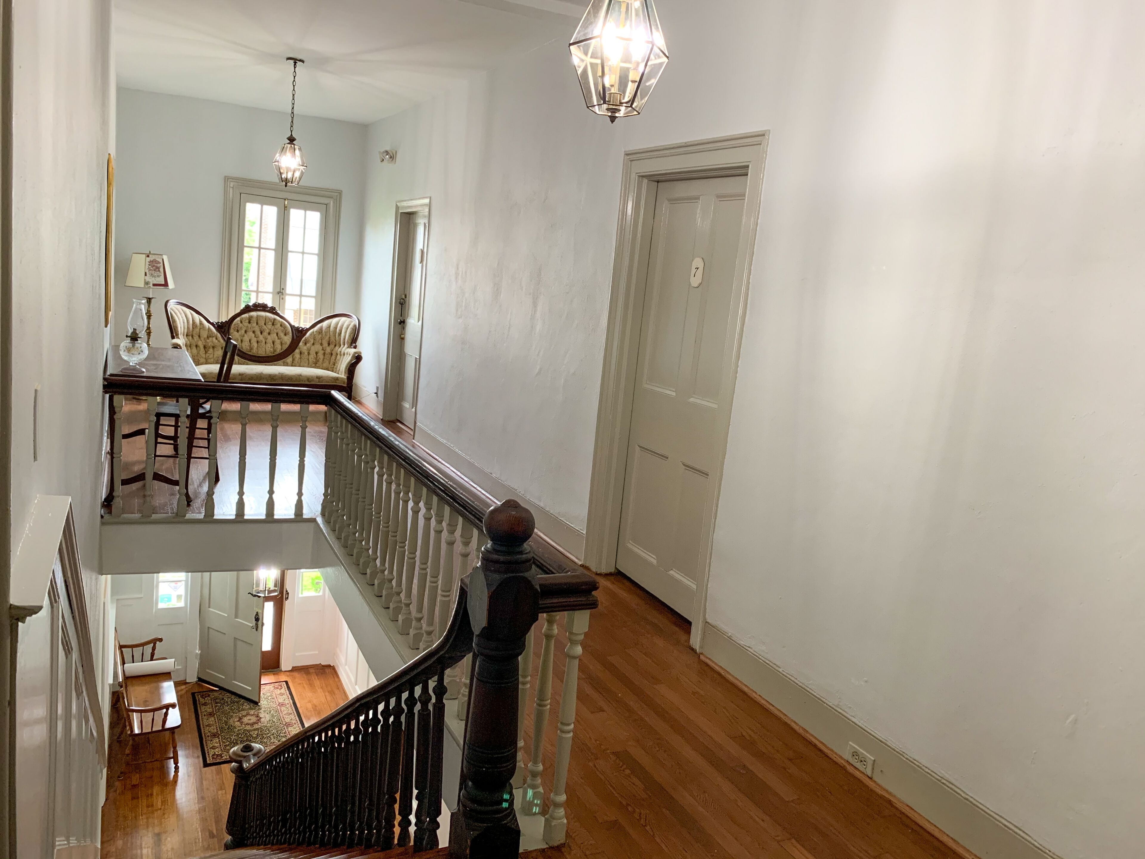 A staircase with a wooden railing leading to a second-floor landing.