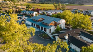 A modern hotel with a flat roof, multiple stories, and a parking area. - Calistoga Motor Lodge and Spa (Calistoga)