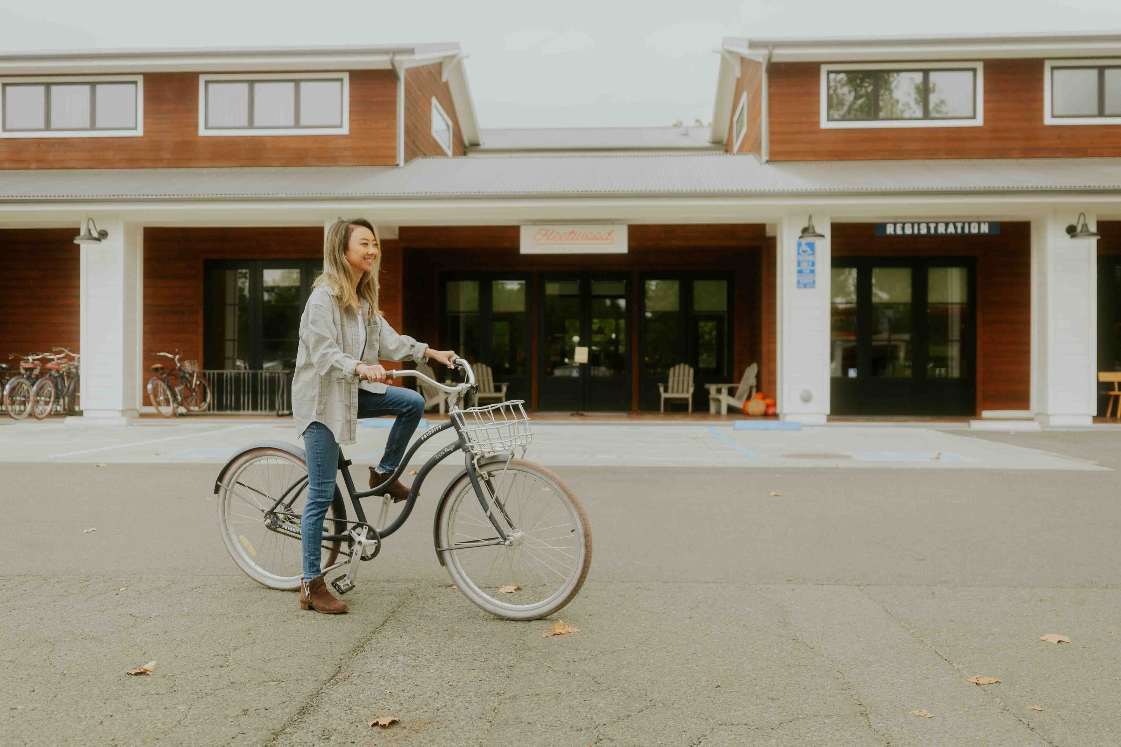 Une personne à vélo devant un bâtiment sur lequel est affiché un panneau indiquant « Inscription ».
