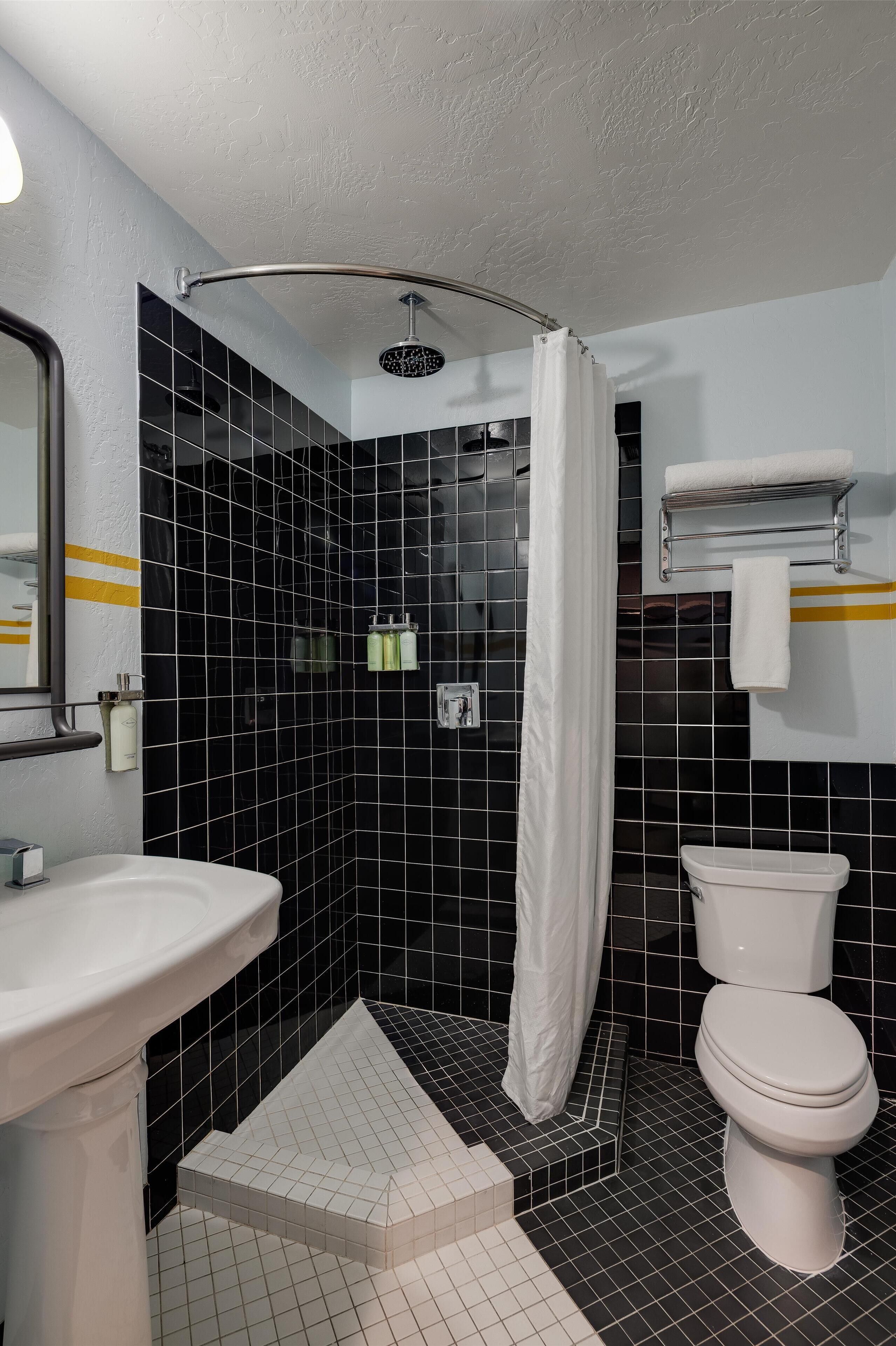 A bathroom with a shower, toilet, and sink.