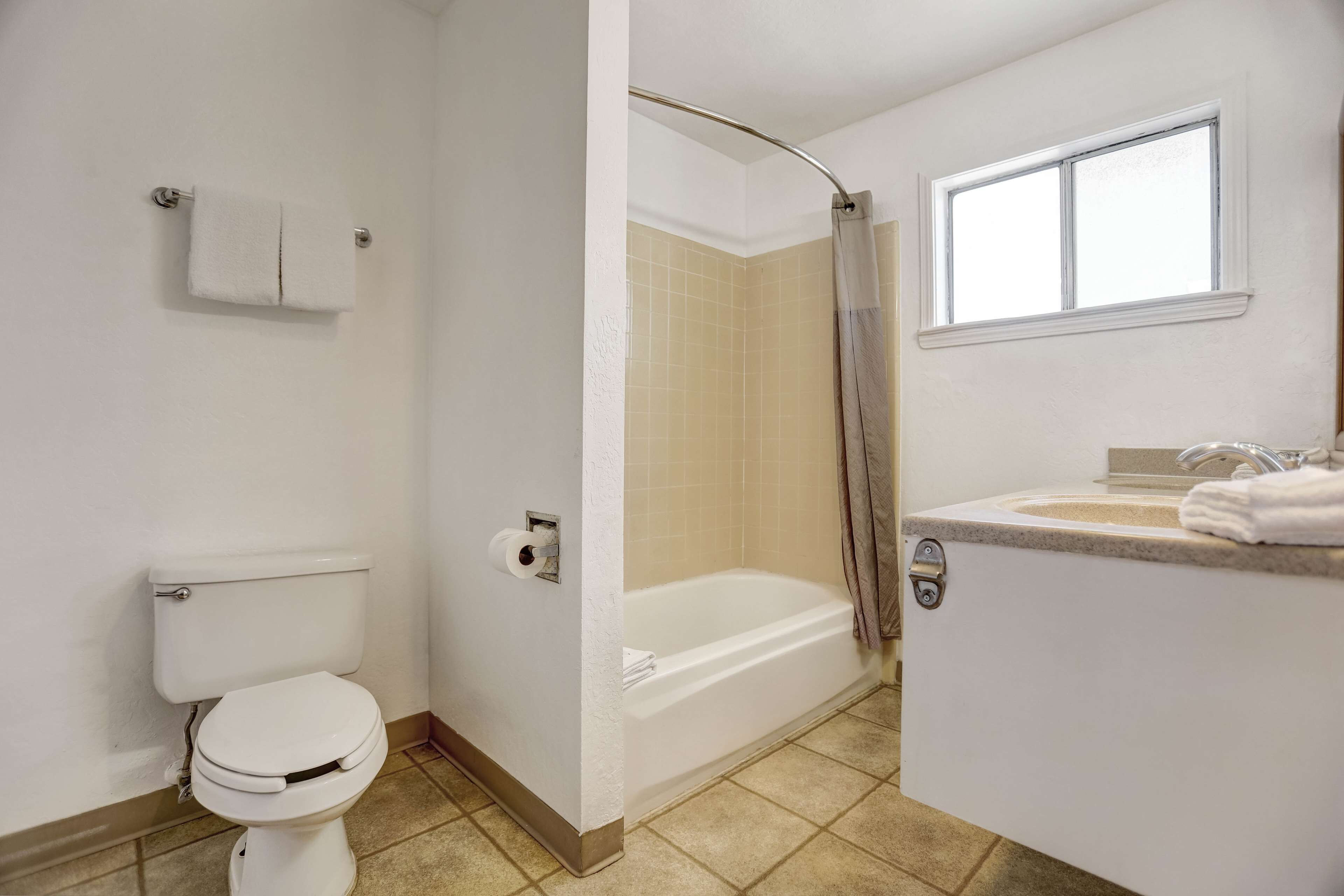 A bathroom with a toilet, a bathtub, and a sink.
