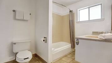 A bathroom with a toilet, a bathtub, and a sink.