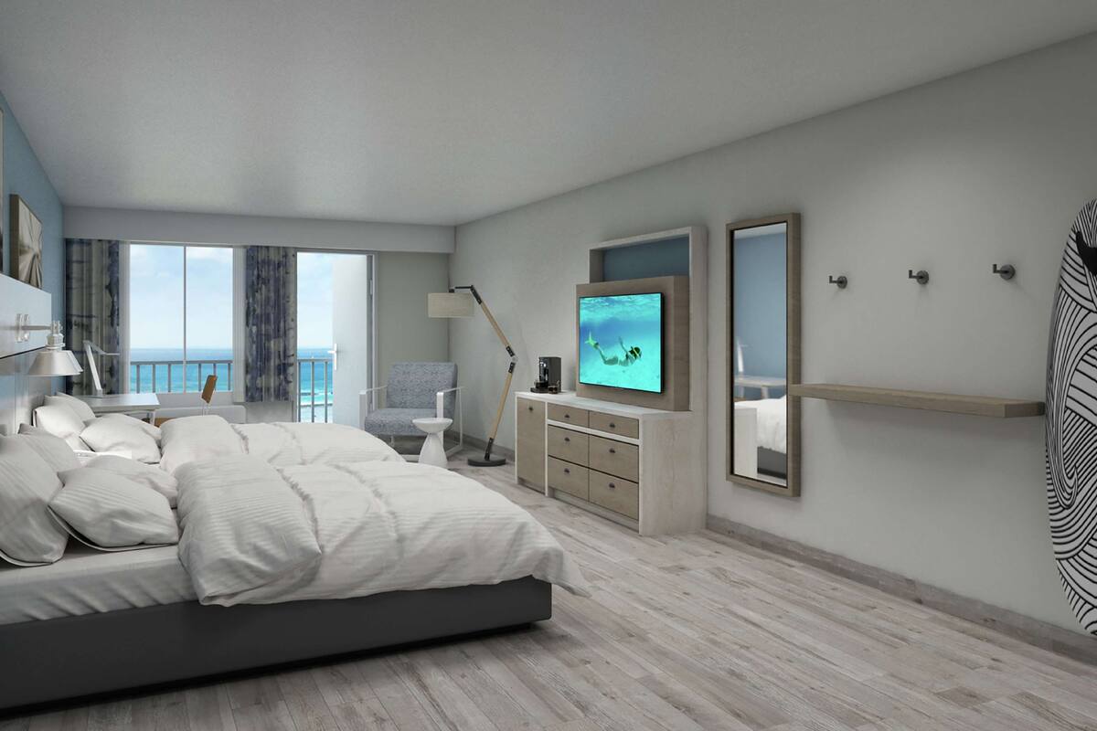 A modern bedroom with a bed, a TV, a desk, and a surfboard.