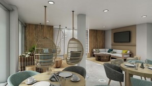 A modern dining area with a round table, chairs, and hanging light fixtures.