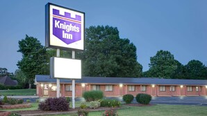 Un hôtel Knights Inn avec une grande enseigne, un bâtiment en briques et un parking.