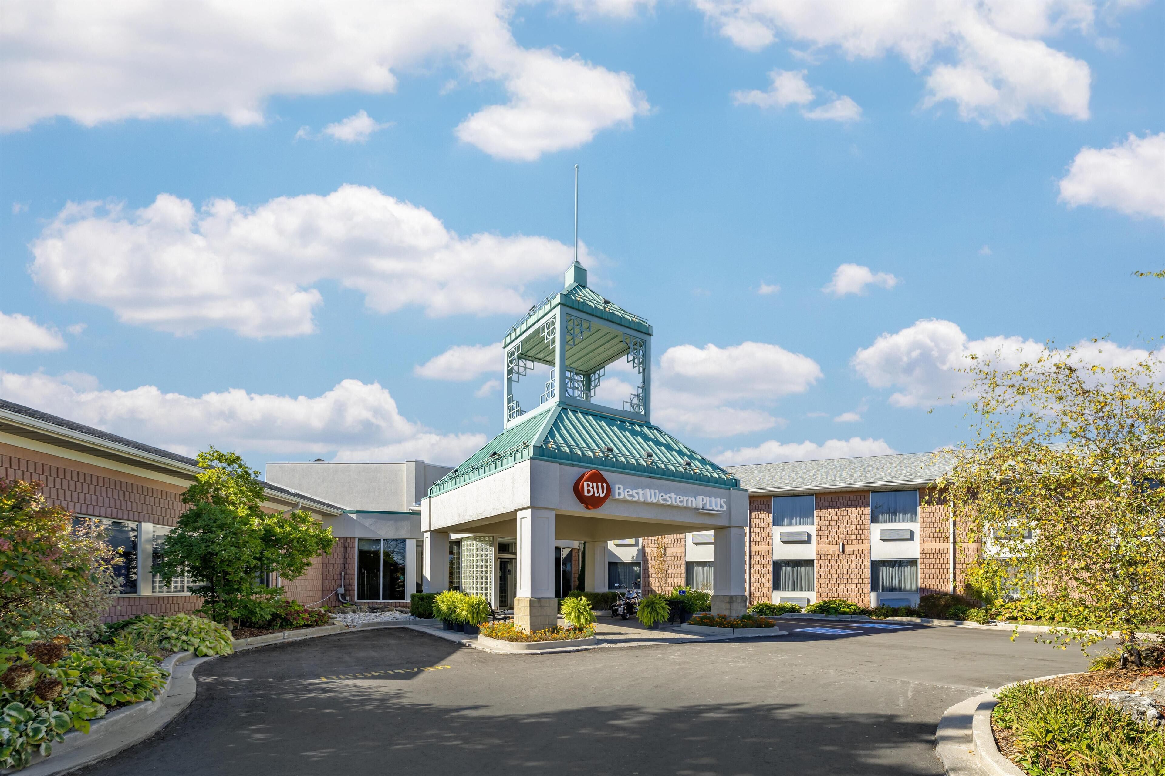 A Best Western Plus hotel with a central tower, brick exterior, and a parking lot.