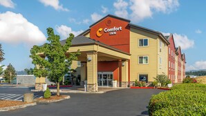 A Comfort Inn hotel with a yellow facade, a covered entrance, and a parking lot. - Comfort Inn Troutdale - Portland East (Troutdale)