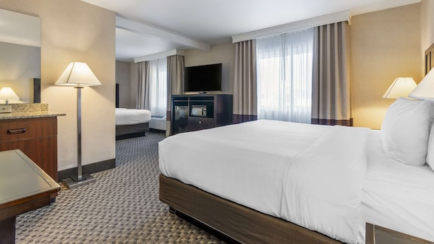 A hotel room with a large bed, a television, a desk, and a mirror. - Comfort Inn Troutdale - Portland East (Troutdale)
