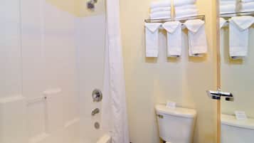 Un baño con bañera, inodoro y perchero para toallas.