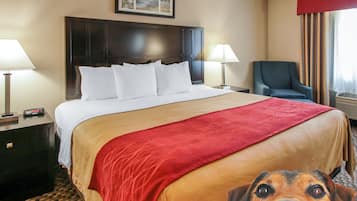 A hotel room with a large bed, two bedside tables, a chair, and a window with curtains.