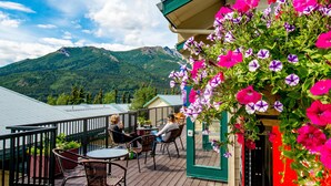 Una terraza con mobiliario exterior y vistas a montañas.