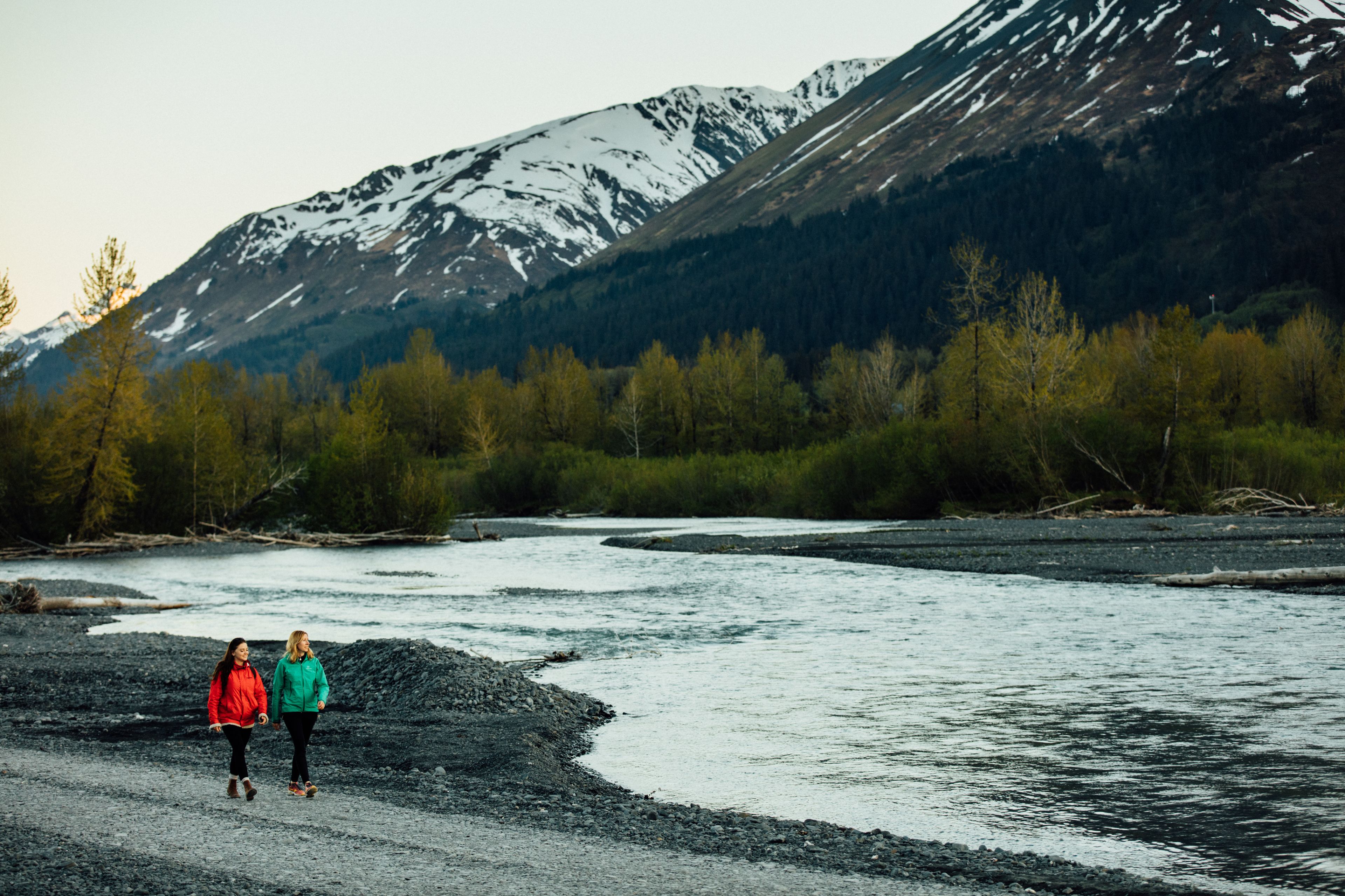 Une rivière aux rives rocheuses, avec des montagnes en arrière-plan.