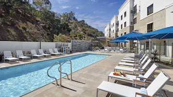 Een buitenzwembad, parasols voor strand/zwembad