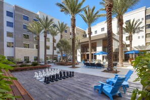 A courtyard with outdoor seating, palm trees, and a chessboard. - Homewood Suites by Hilton San Diego Hotel Circle/SeaWorld Area (San Diego)