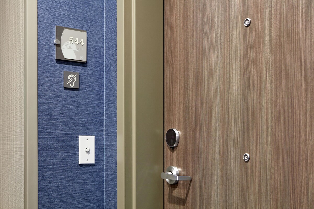 A door with a number plate, a doorbell, and a door handle.