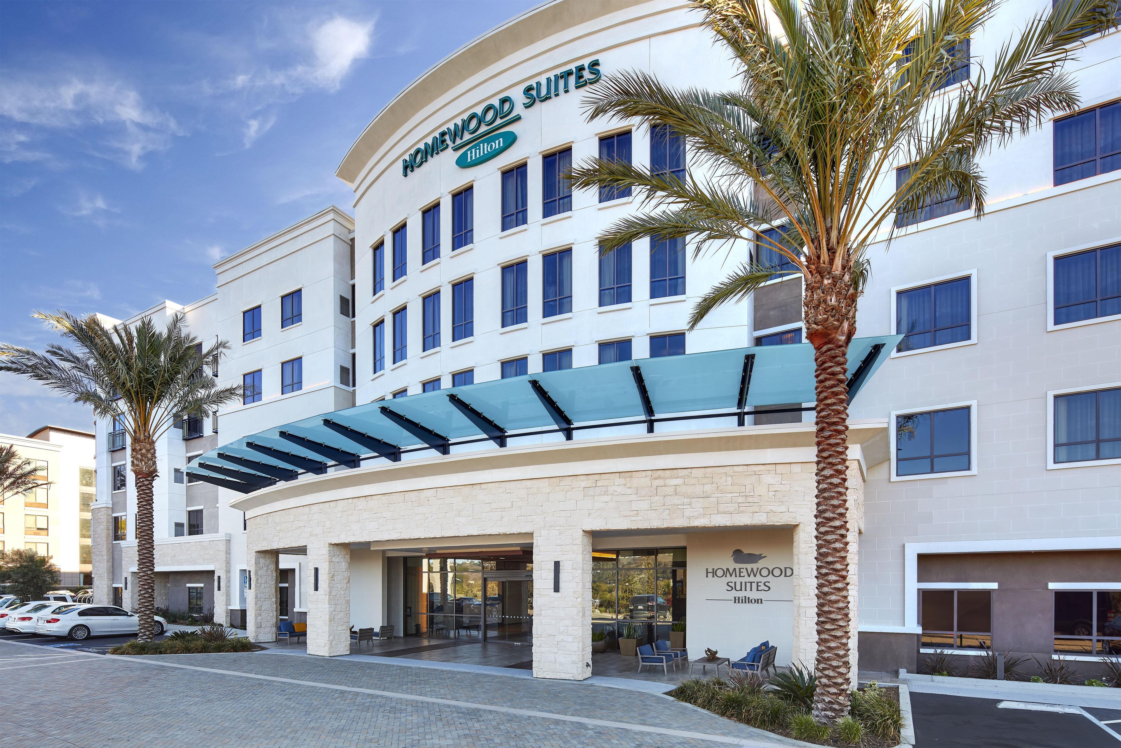 A hotel with a modern facade, multiple windows, and a covered entrance area.
