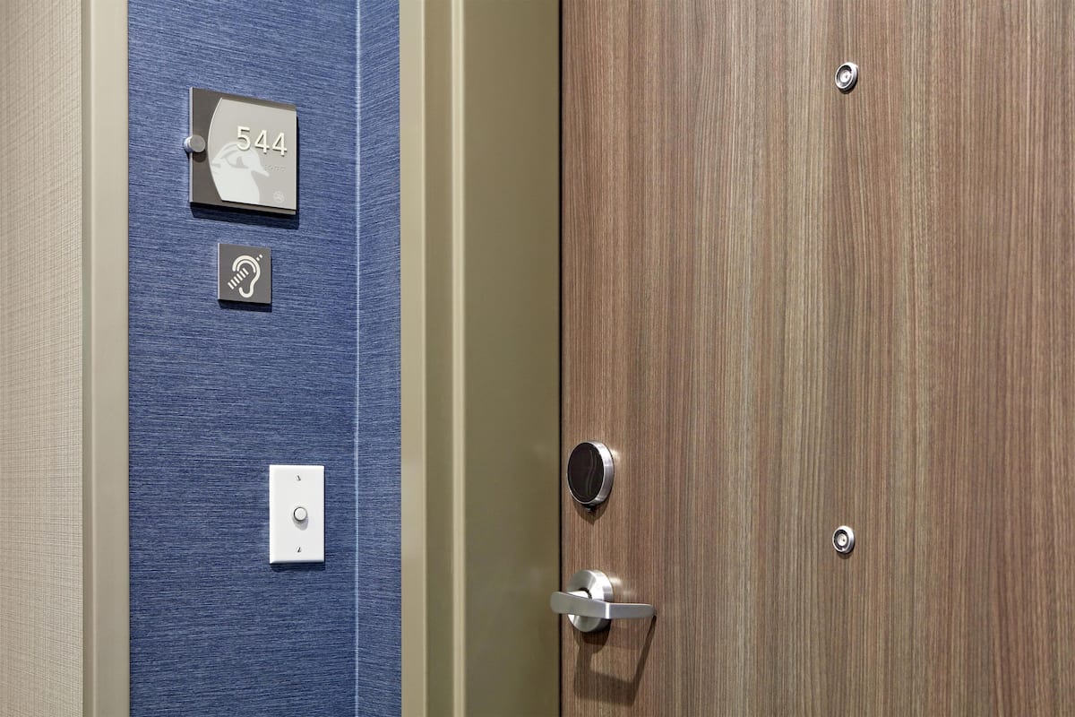 Una puerta con una placa de número, un timbre y un picaporte.
