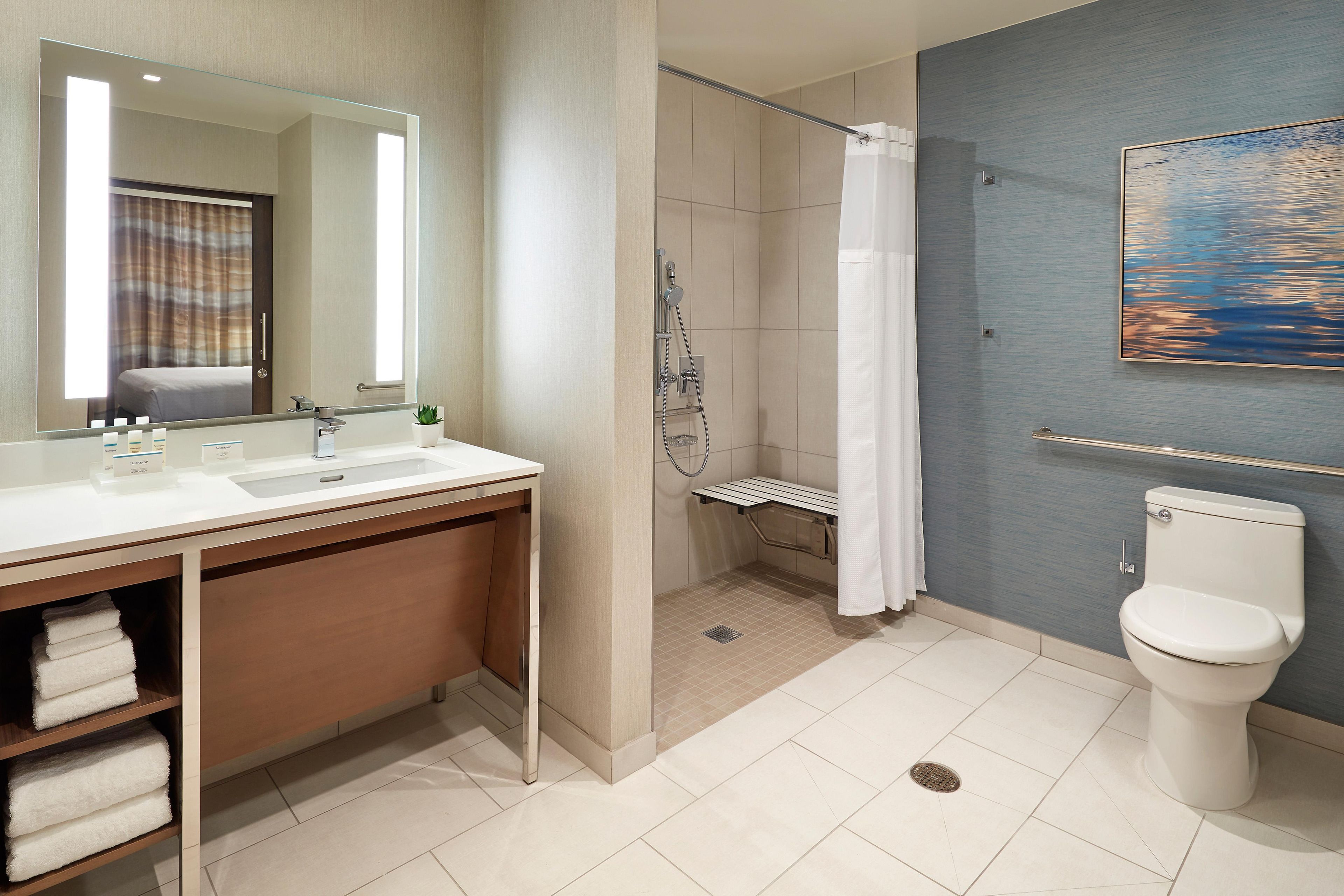 A modern bathroom with a shower, toilet, and sink.