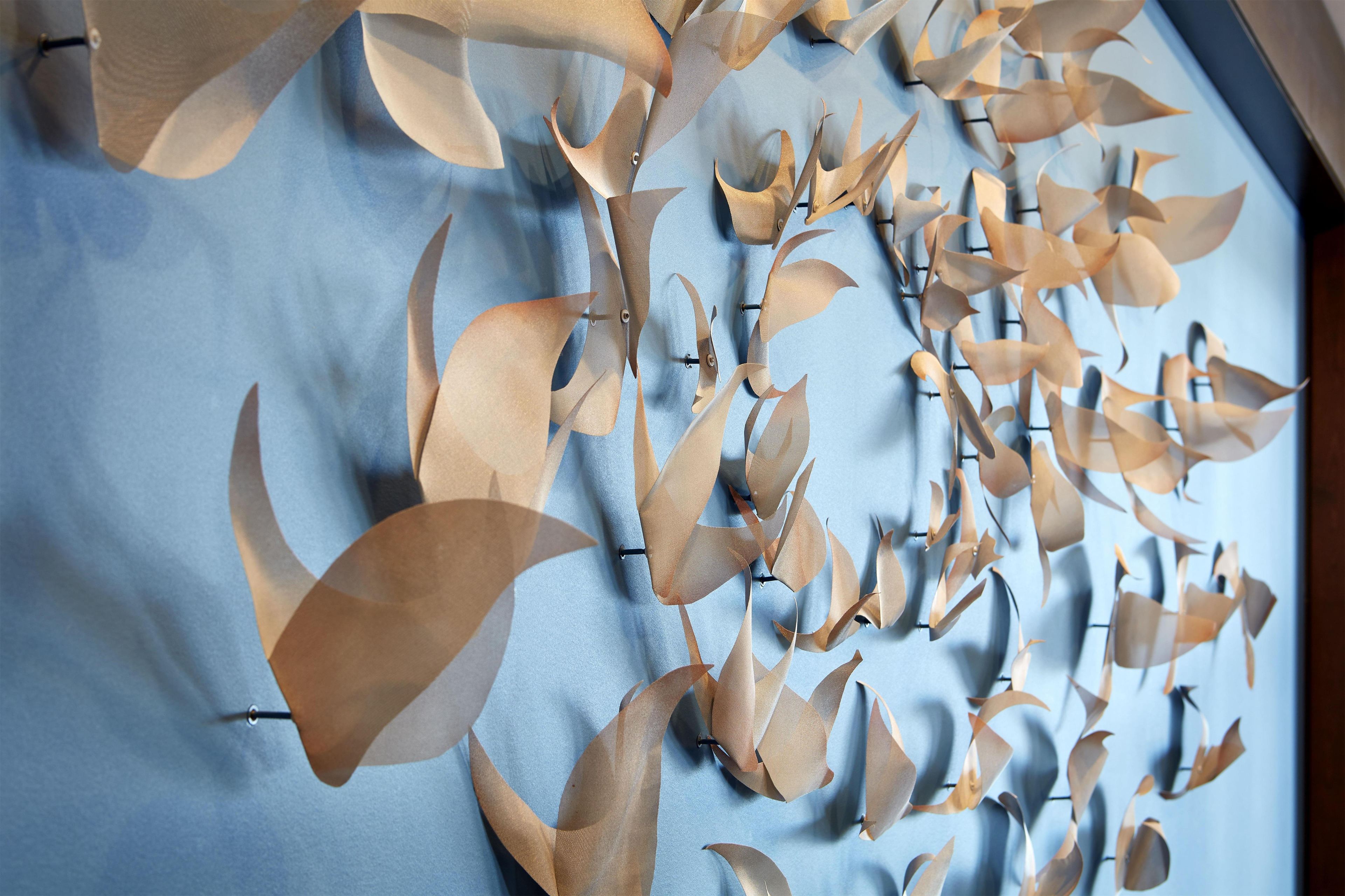 A wall with a pattern of leaf-like decorations.
