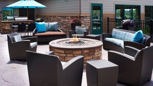 An outdoor patio with wicker furniture, a fire pit, and a grill area. - Residence Inn by Marriott Ann Arbor North (Ann Arbor)