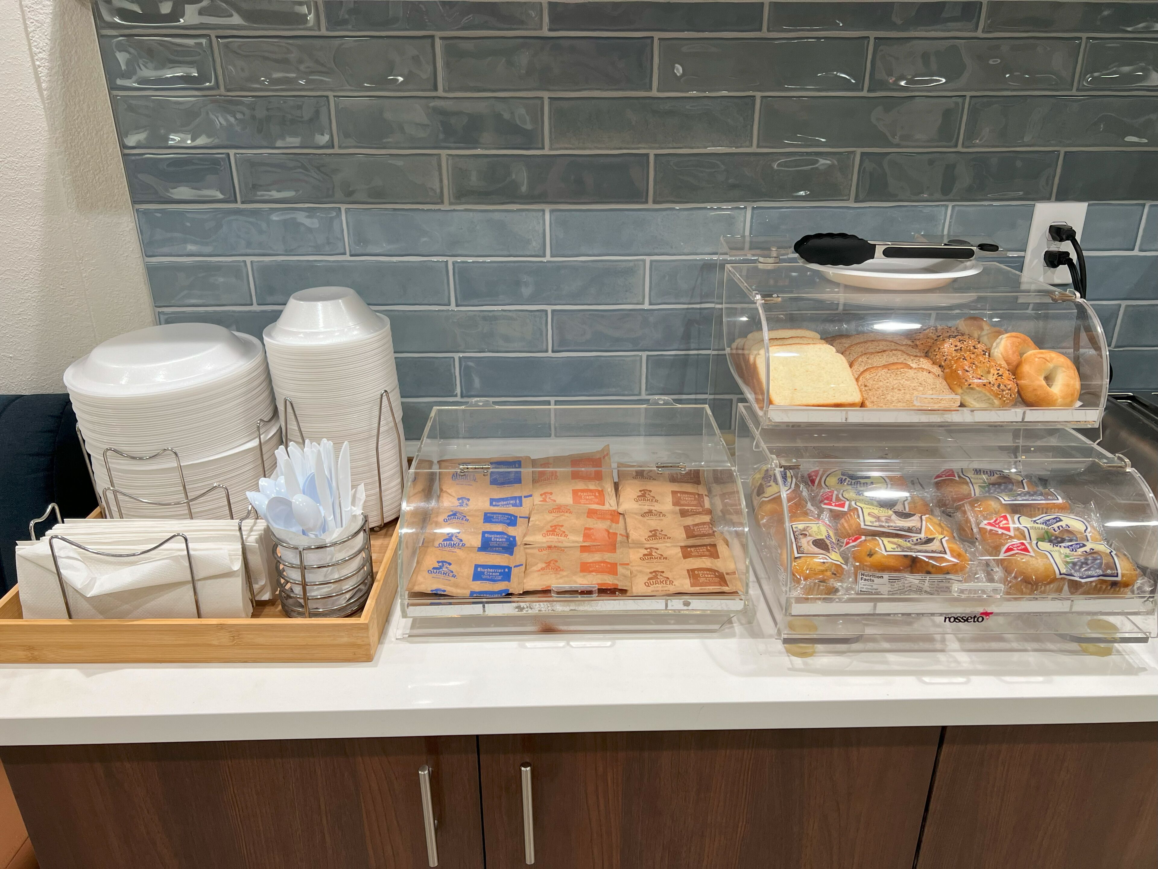 A breakfast buffet with various food items, including bread, pastries, and coffee.