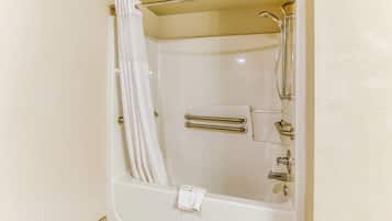 Eine weiße Badewanne mit Duschkopf, Handtuchhalter und einer flexiblen Duschbrause.