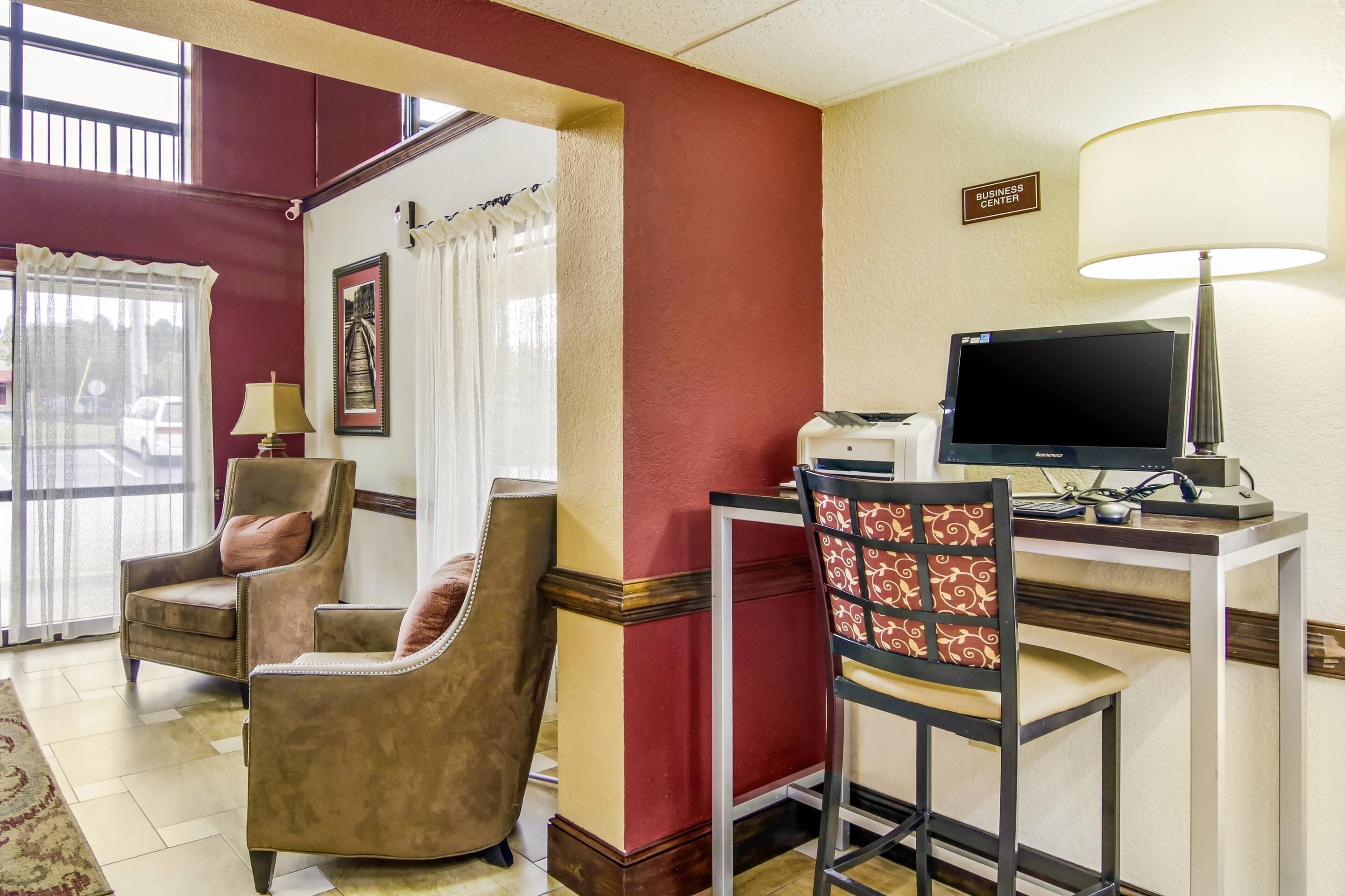 Une chambre d’hôtel équipée d’un bureau, d’un ordinateur et de deux chaises.