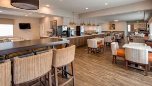 A modern restaurant with bar seating, a coffee machine, and a TV.