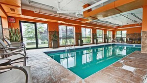 An indoor swimming pool with clear glass walls, potted plants, and outdoor views. - Comfort Inn & Suites Copley Akron (Akron)
