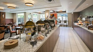 A buffet setup with various food stations, including scrambled eggs and a coffee station.