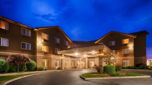 A multi-story hotel with a covered entrance and a landscaped driveway.