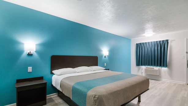 A bedroom with a bed, bedside tables, and a window with curtains. - Motel 6 Metropolis, IL (Metropolis)