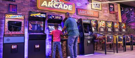 An arcade with neon signs and various gaming machines.