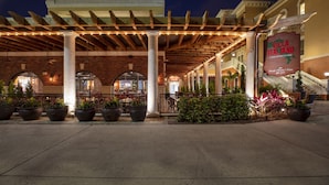A covered outdoor area with columns, potted plants, and a sign for Villa Italiana Chophouse. - Westgate Vacation Villas Resort (Kissimmee)