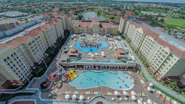 Un hotel con zona de piscina central, varias toboganes de agua y una piscina circundante.